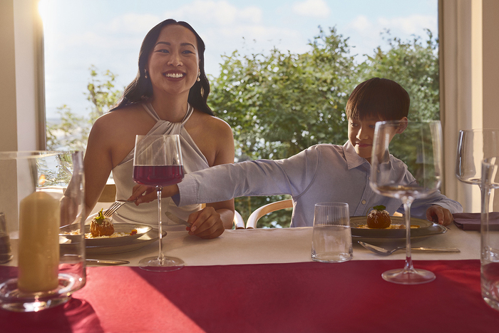 Woman and boy laughing at table by window together