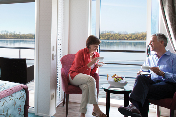 A couple drinking tea in their cabin on a river cruise