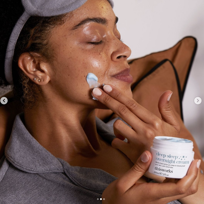 Model applying night cream in pyjamas