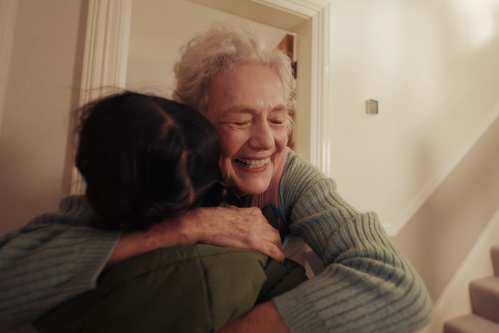 Classic model hugging child smiling with eyes closed