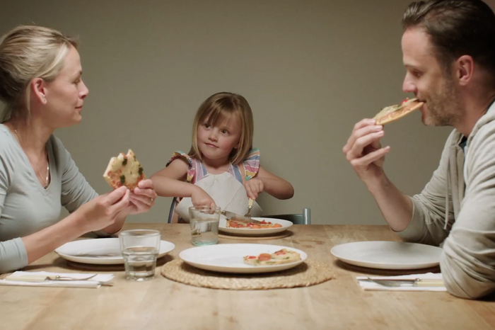 Family of three eating pizza together
