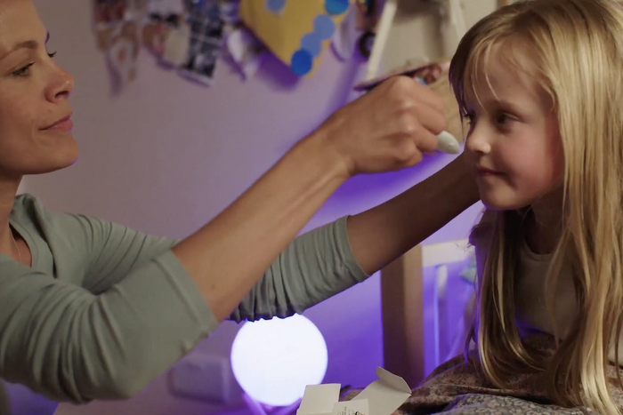 Mother giving cough syrup to Daughter