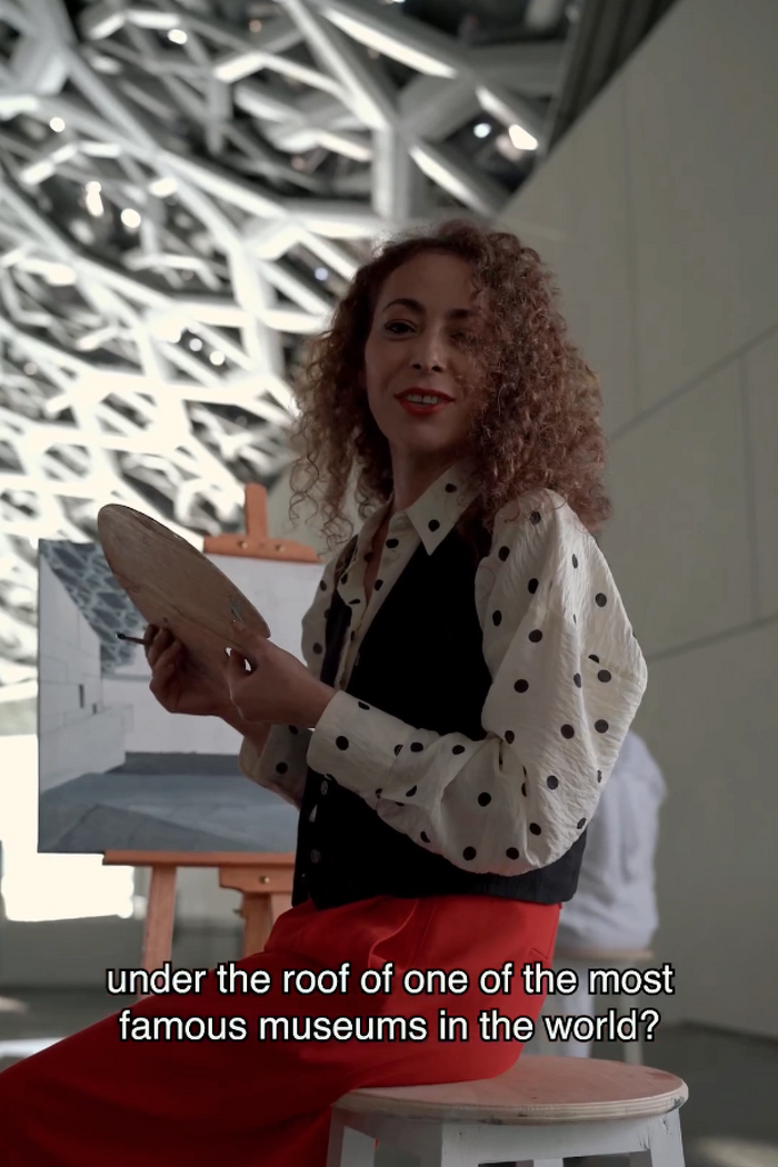 Female model painting at an easel