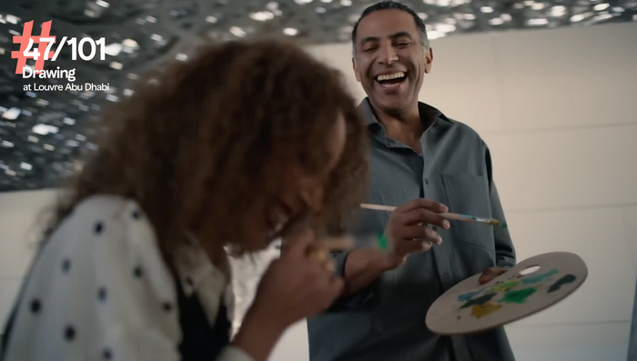 Model couple laughing and painting together