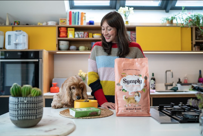 Female actor smiling and feeding dog