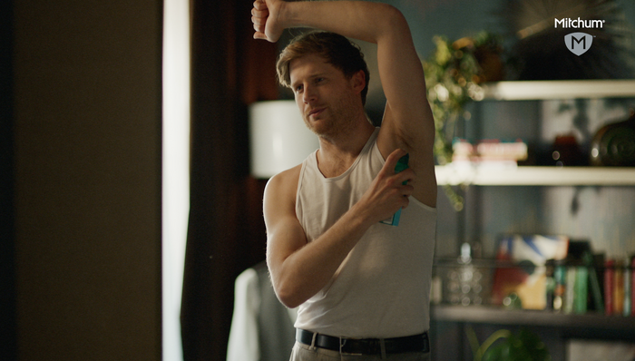 Male model spraying on deodorant