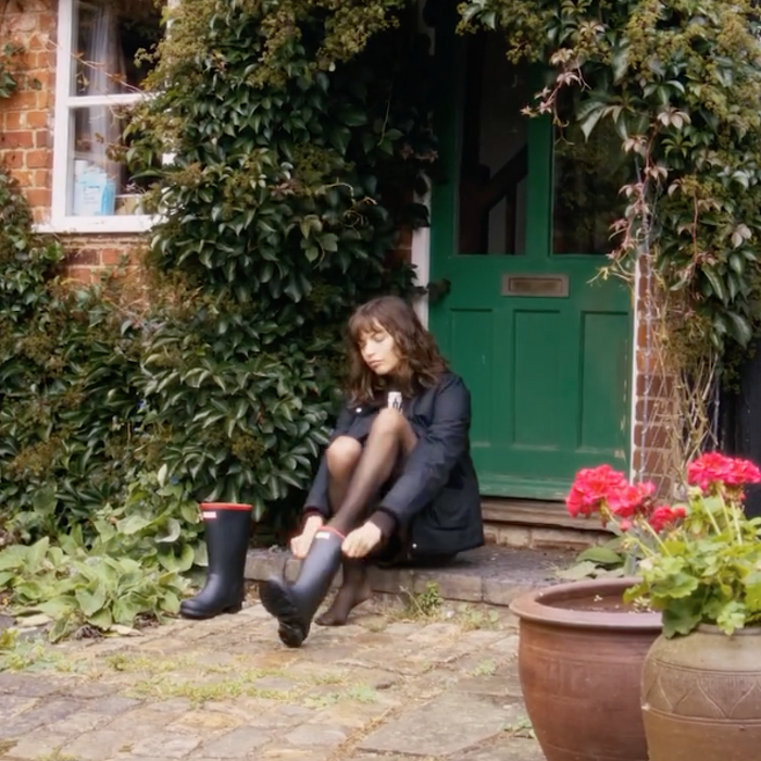 Female model sat down putting on boots