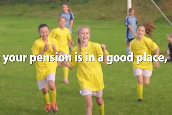 Girls football team on pitch celebrating a goal