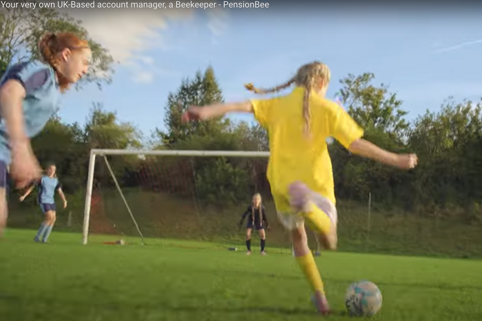 Girl playing football about to score a goal