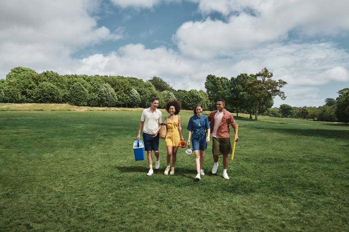 Four models walking in field on a sunny day