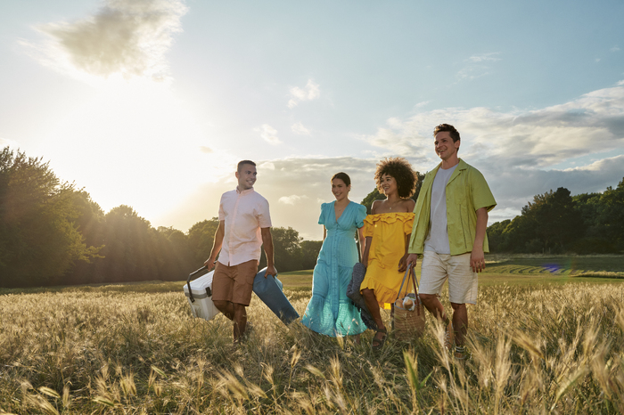 Four models walking in field on a sunny day