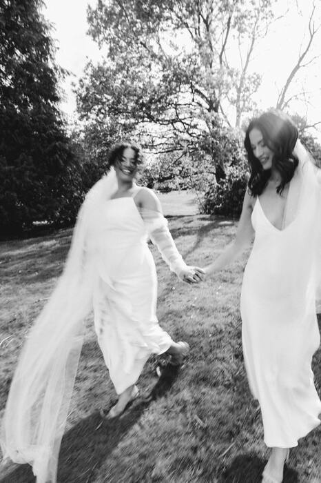 Two brides running hand in hand