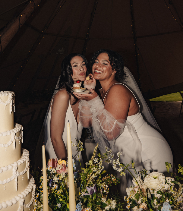 Two brides sharing cake