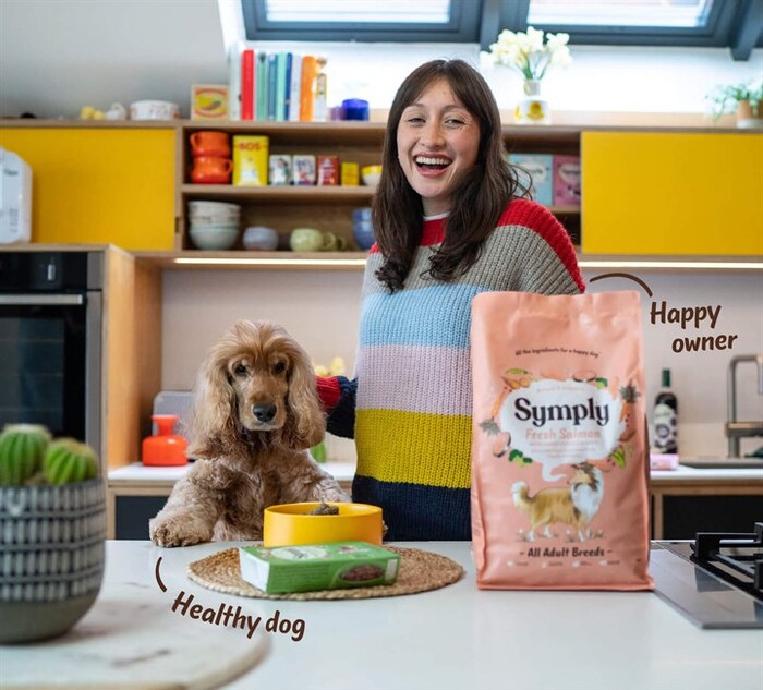 Female actor smiling and feeding dog